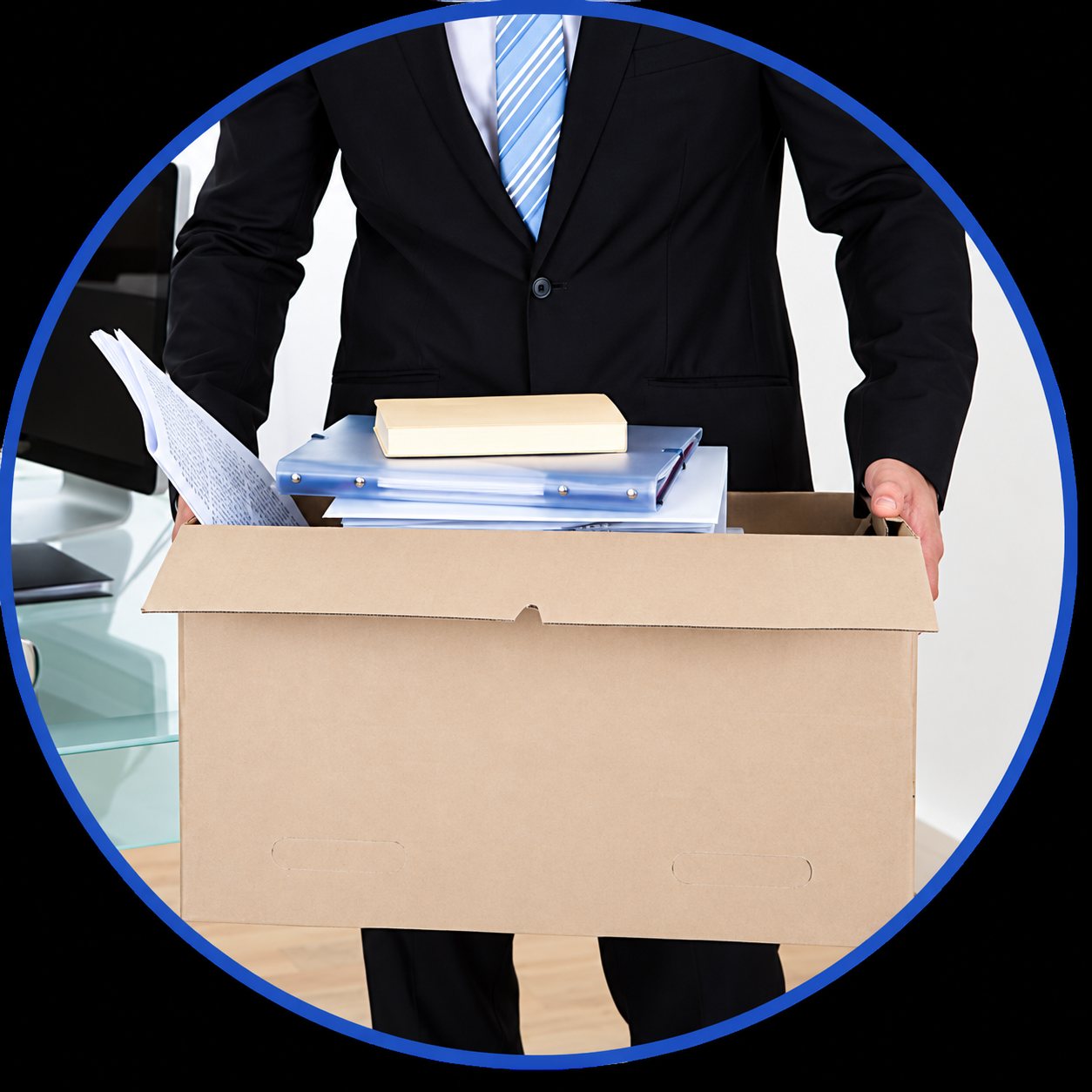 Un homme en costume et cravate bleue porte un carton rempli de dossiers et de documents dans un bureau.